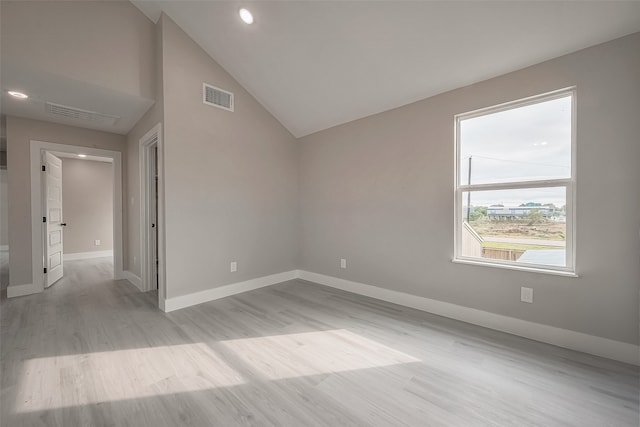 empty room featuring light hardwood / wood-style flooring and vaulted ceiling