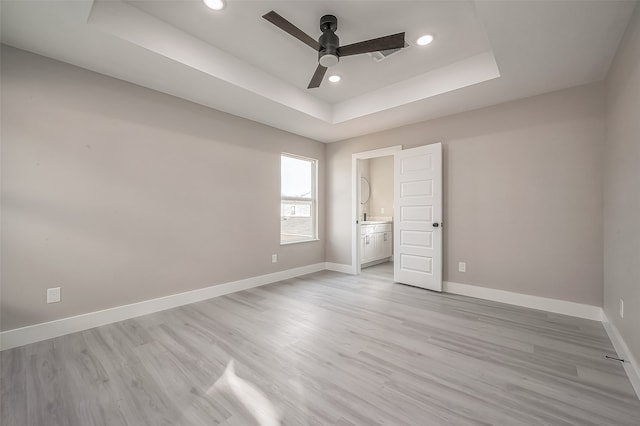 unfurnished bedroom featuring ensuite bath, light hardwood / wood-style floors, and ceiling fan