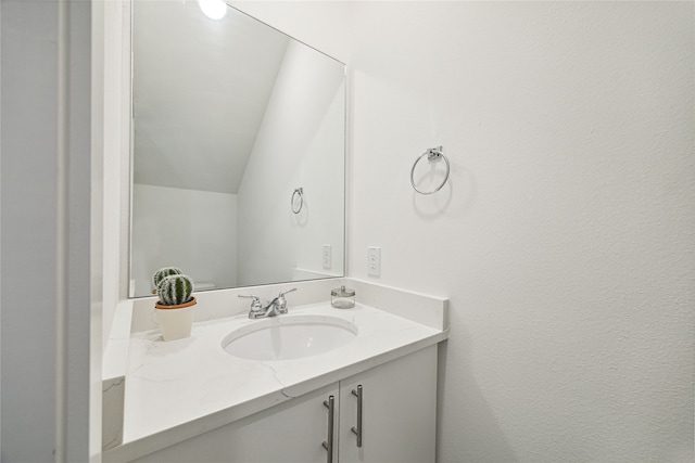 bathroom with vanity and lofted ceiling