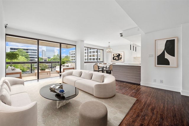 living room with dark wood-type flooring and an inviting chandelier