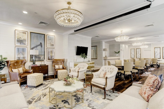 living room with a notable chandelier, wood-type flooring, and ornamental molding