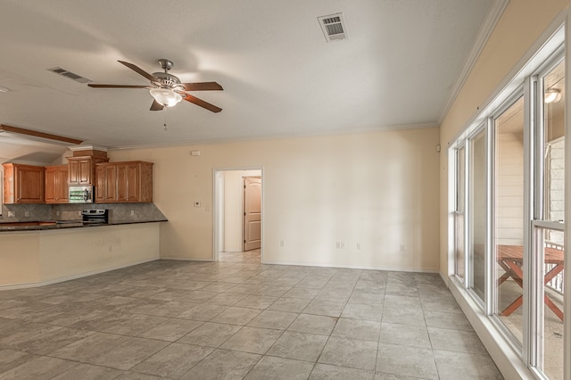 unfurnished living room featuring ceiling fan, a healthy amount of sunlight, and ornamental molding