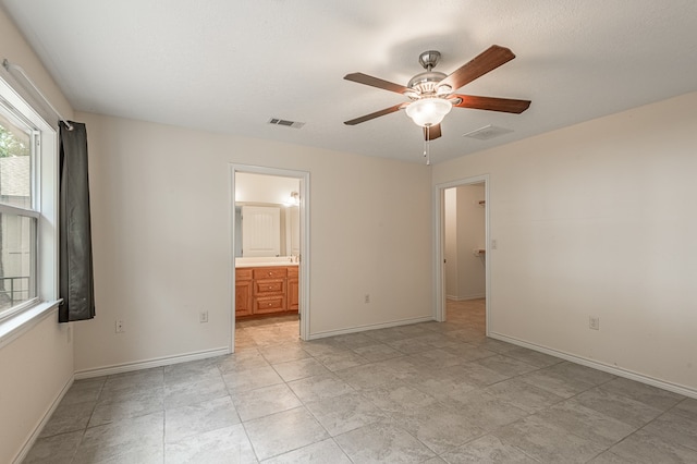 unfurnished bedroom with ensuite bathroom and ceiling fan