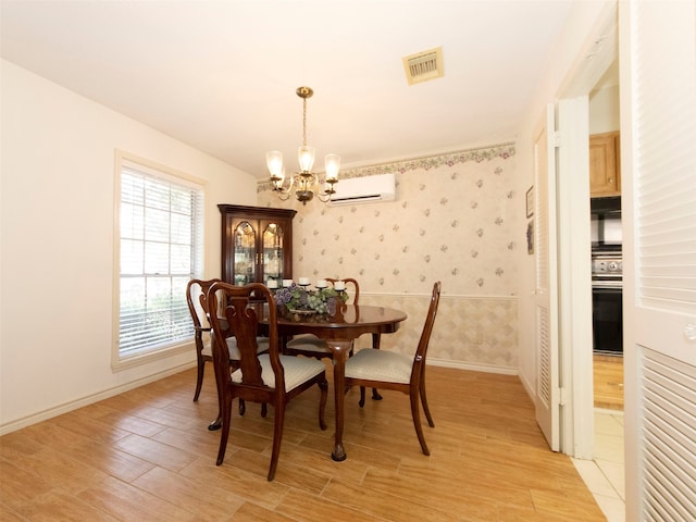 dining space with a chandelier, a wall mounted AC, and light wood-type flooring