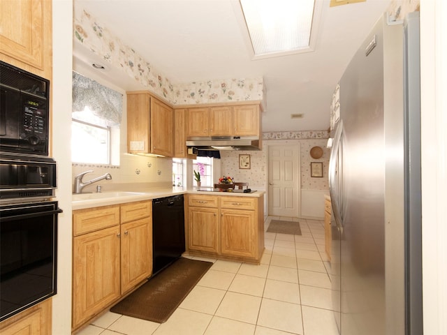 kitchen featuring light tile patterned floors, black appliances, and sink