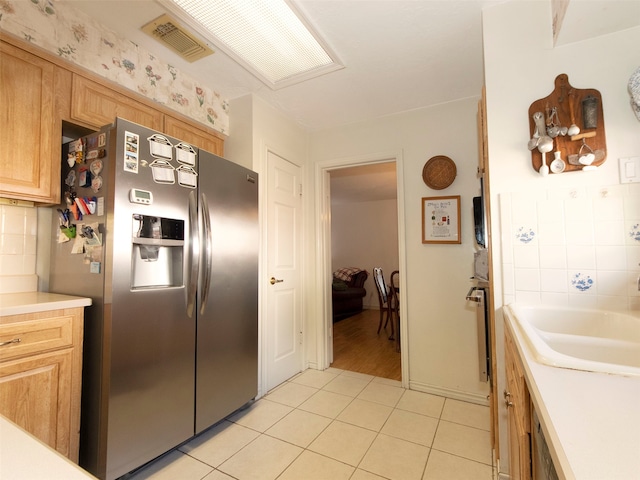 kitchen with light brown cabinets, stainless steel refrigerator with ice dispenser, and light tile patterned floors