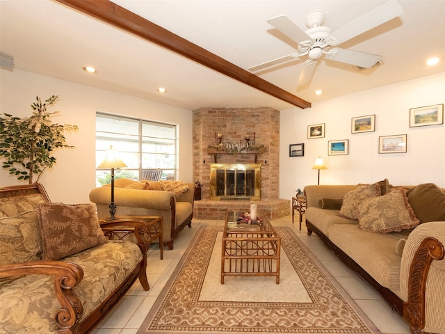 living room with a brick fireplace, beamed ceiling, light tile patterned floors, and ceiling fan