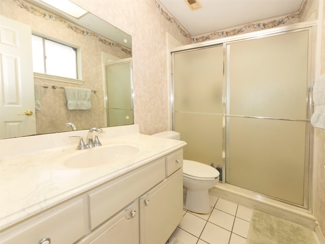 bathroom with vanity, a shower with shower door, toilet, and tile patterned floors