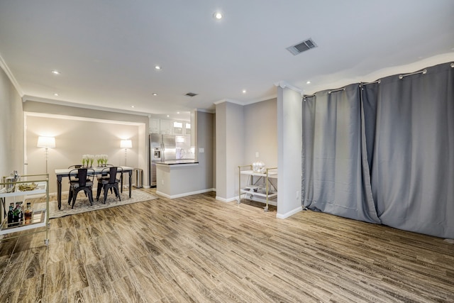 interior space with crown molding and light hardwood / wood-style floors