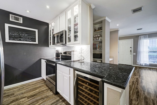 kitchen with dark wood-type flooring, stainless steel appliances, crown molding, beverage cooler, and white cabinets