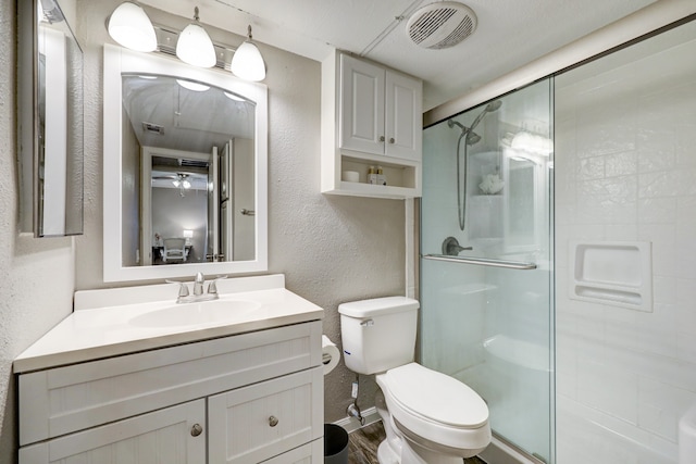 bathroom featuring vanity, wood-type flooring, toilet, and an enclosed shower