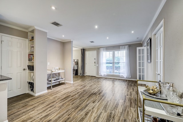 unfurnished living room with wood-type flooring and ornamental molding