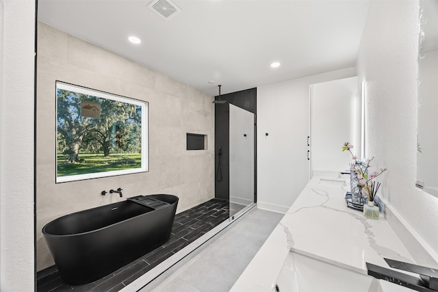 bathroom with vanity, tile walls, and walk in shower