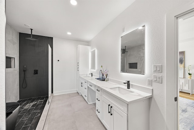 bathroom featuring tiled shower and vanity