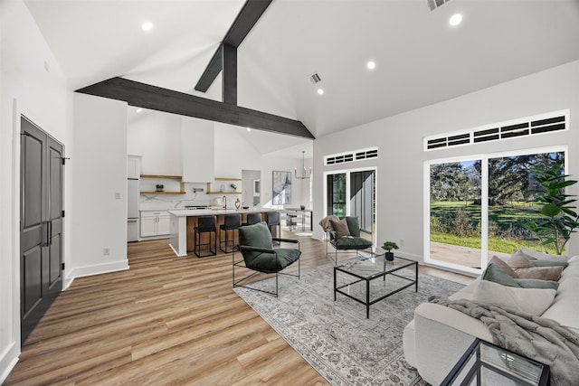 living room with beamed ceiling, sink, high vaulted ceiling, and light hardwood / wood-style flooring