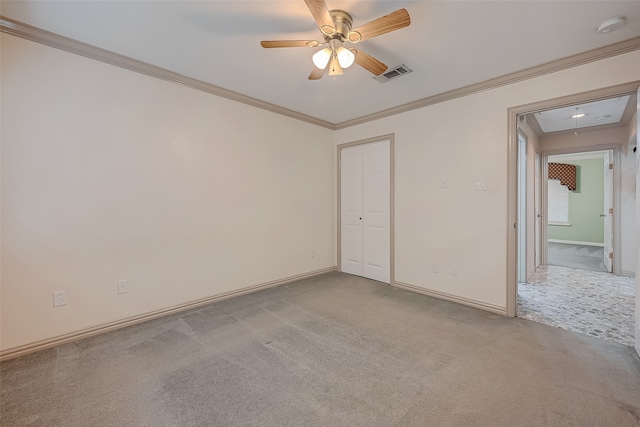 unfurnished bedroom with crown molding, light carpet, a closet, and ceiling fan