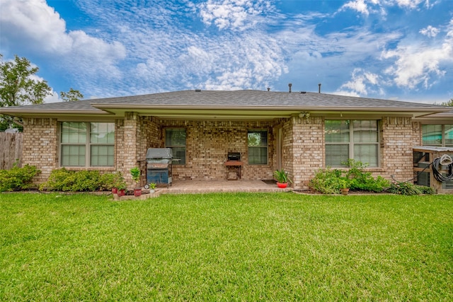 rear view of house with a yard and a patio area