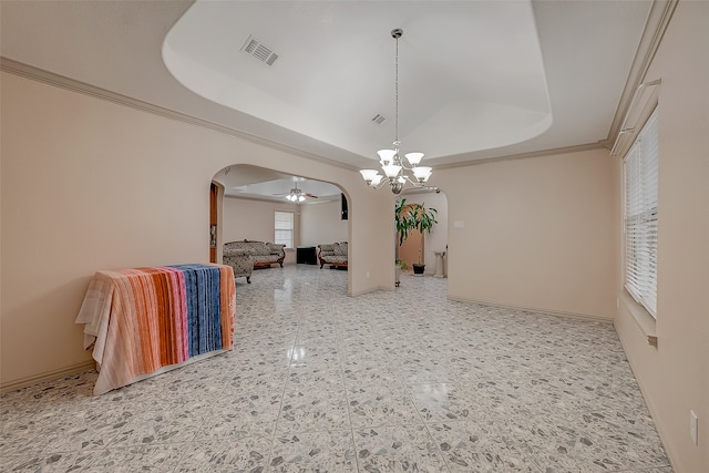 unfurnished dining area featuring crown molding, ceiling fan with notable chandelier, and a raised ceiling