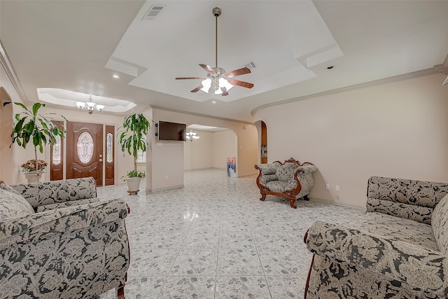 living room with ceiling fan with notable chandelier and a raised ceiling