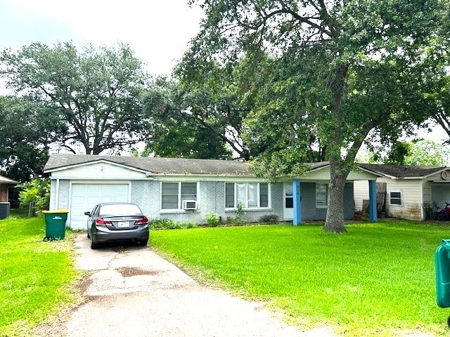 ranch-style home featuring a front yard, a garage, and central AC unit