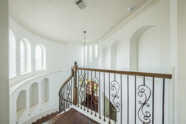 hallway with ornamental molding and a chandelier