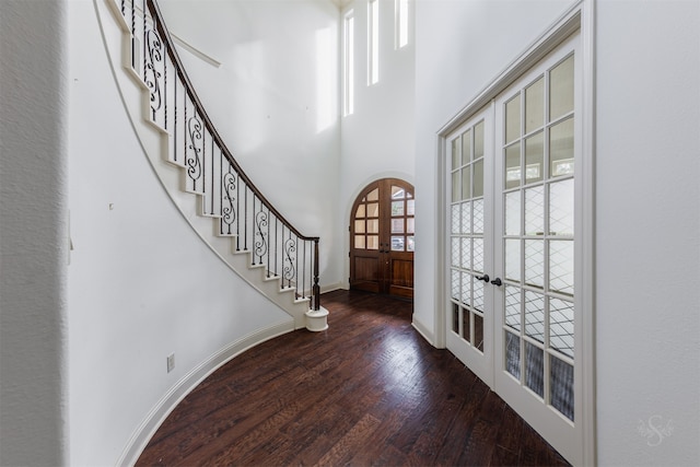 foyer with dark hardwood / wood-style flooring, a high ceiling, and french doors