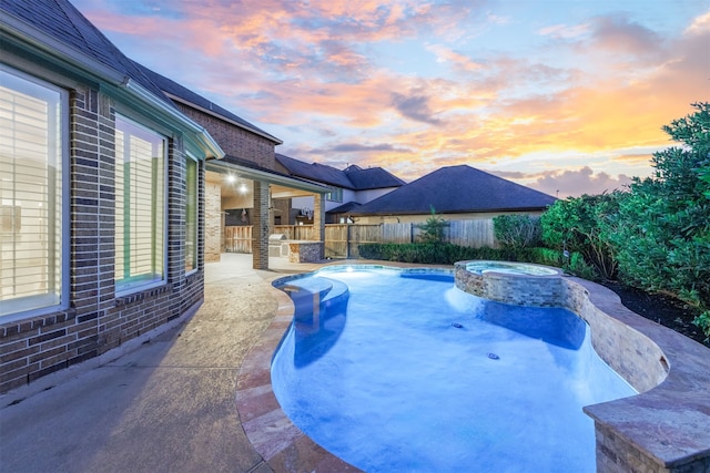 pool at dusk featuring an in ground hot tub and a patio