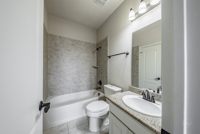 full bathroom with vanity, tile patterned floors, tiled shower / bath, toilet, and a textured ceiling