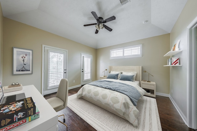 bedroom with ceiling fan, dark wood-type flooring, and vaulted ceiling