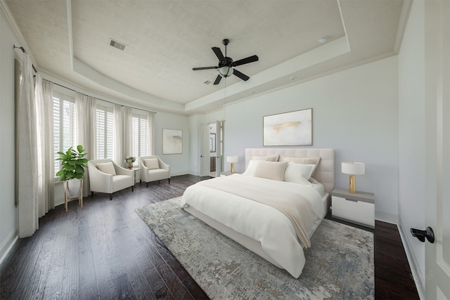 bedroom featuring dark hardwood / wood-style floors, ceiling fan, and a tray ceiling