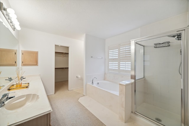 bathroom featuring vanity, a textured ceiling, and plus walk in shower