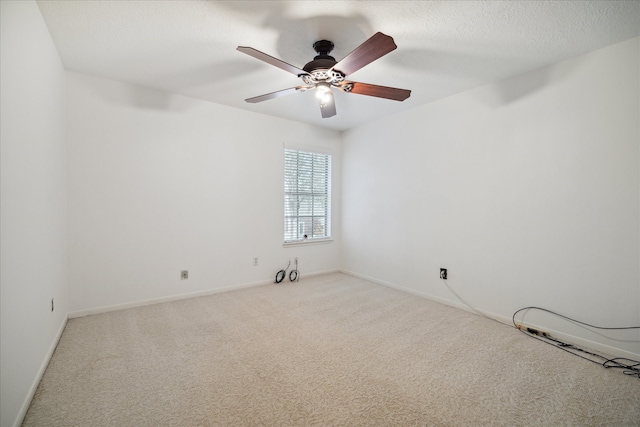 carpeted spare room with a textured ceiling and ceiling fan