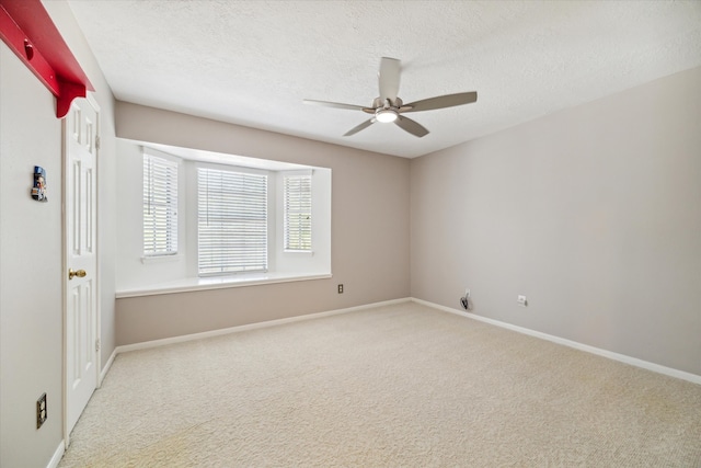 spare room featuring a textured ceiling, carpet flooring, and ceiling fan