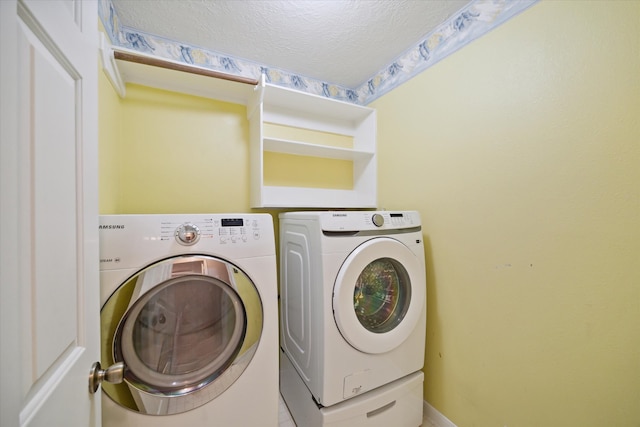 clothes washing area with washer and dryer and a textured ceiling