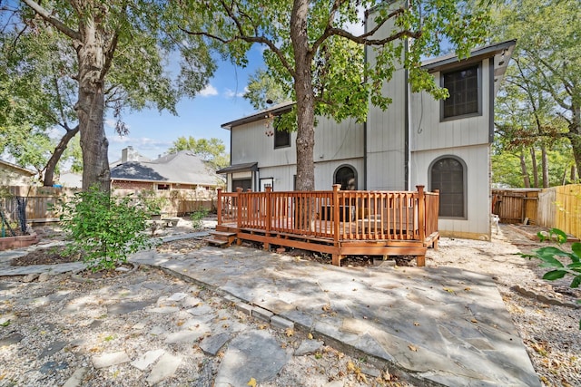 back of house with a deck and a patio area