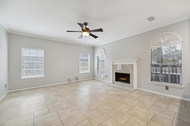 unfurnished living room with a high end fireplace, ornamental molding, and plenty of natural light