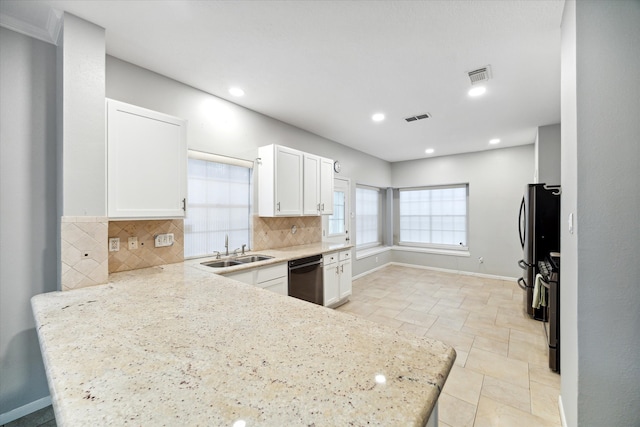 kitchen with appliances with stainless steel finishes, white cabinetry, light stone counters, and backsplash