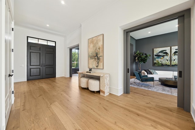 foyer entrance featuring ornamental molding and light hardwood / wood-style floors