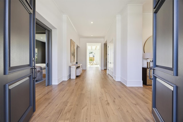 foyer with ornamental molding and light wood-type flooring