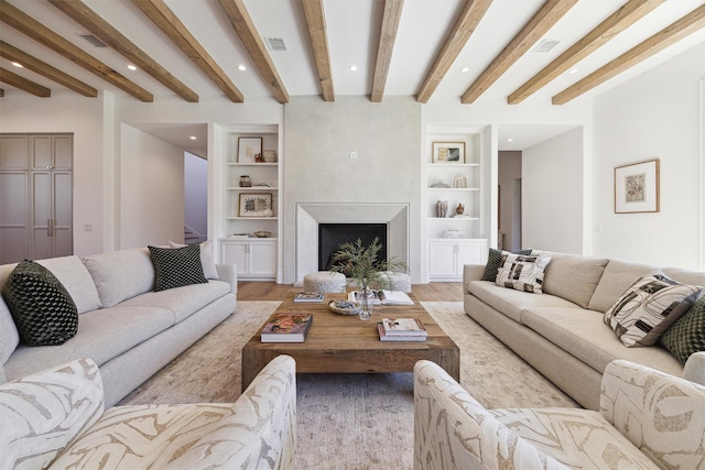 living room featuring beamed ceiling, light hardwood / wood-style floors, and built in features