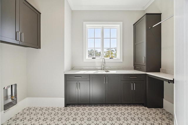 washroom featuring crown molding, cabinets, and sink