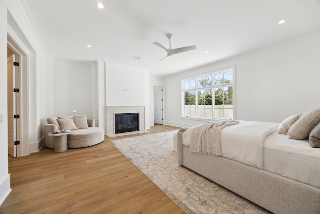 bedroom with ornamental molding, ceiling fan, and light wood-type flooring