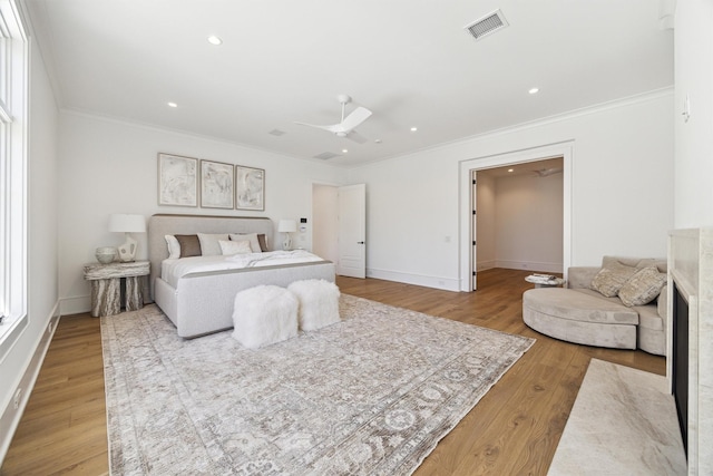 bedroom with ornamental molding, ceiling fan, and light wood-type flooring