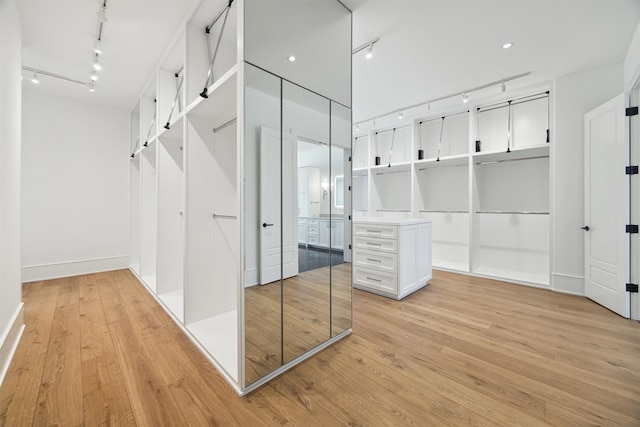 walk in closet with light hardwood / wood-style floors