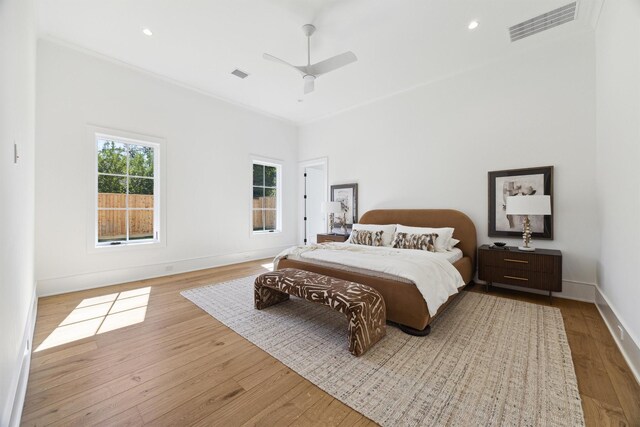 bedroom featuring ceiling fan, light wood-type flooring, and crown molding