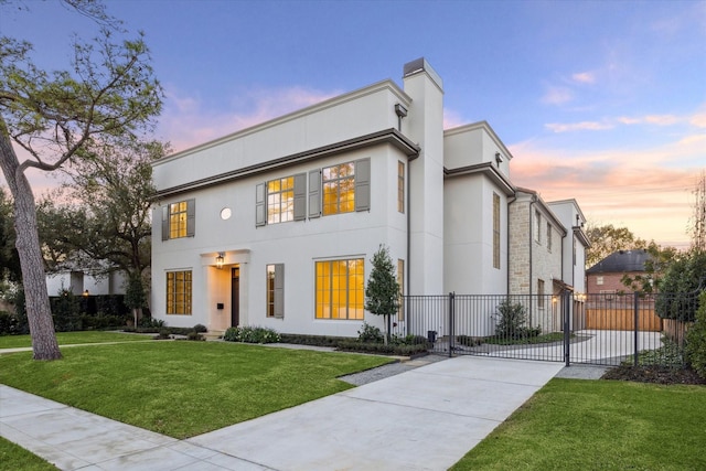 view of front of home featuring a yard, fence, a gate, and stucco siding