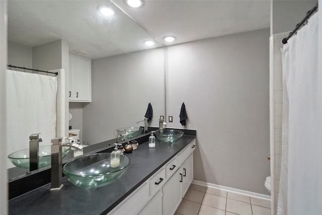 bathroom with walk in shower, vanity, toilet, and tile patterned floors