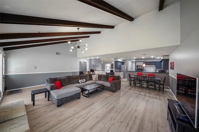 living room with light hardwood / wood-style floors, high vaulted ceiling, beam ceiling, and an inviting chandelier