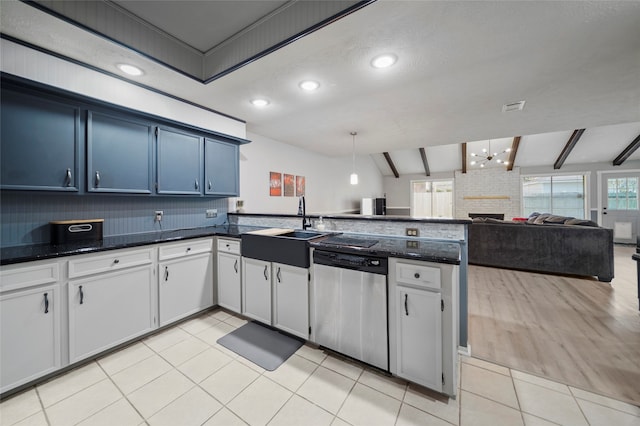 kitchen featuring stainless steel dishwasher, vaulted ceiling with beams, a fireplace, and plenty of natural light