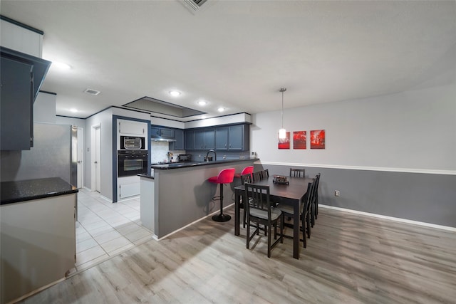 dining area with sink and light hardwood / wood-style flooring